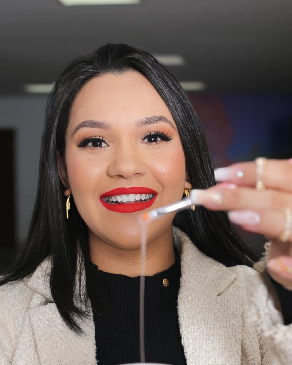 Mayara Saldanha segurando o pincel de gel em retrato de estúdio