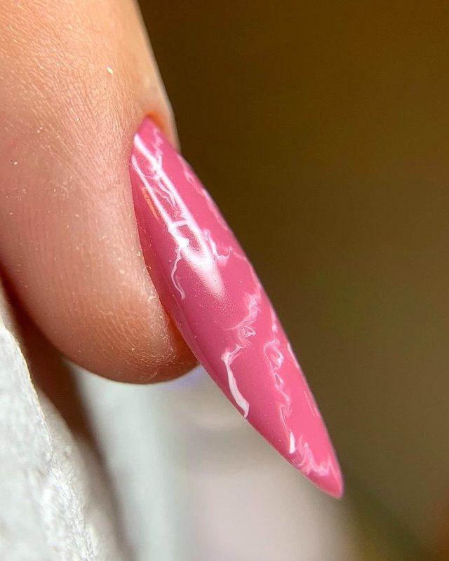 Unha em formato almond esmaltada em rosa, acabamento em gel