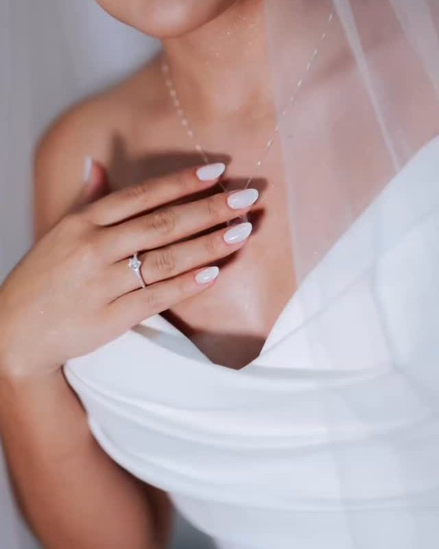 Noiva com as mãos no colo do vestido, mostrando as unhas feitas por Mayara Saldanha